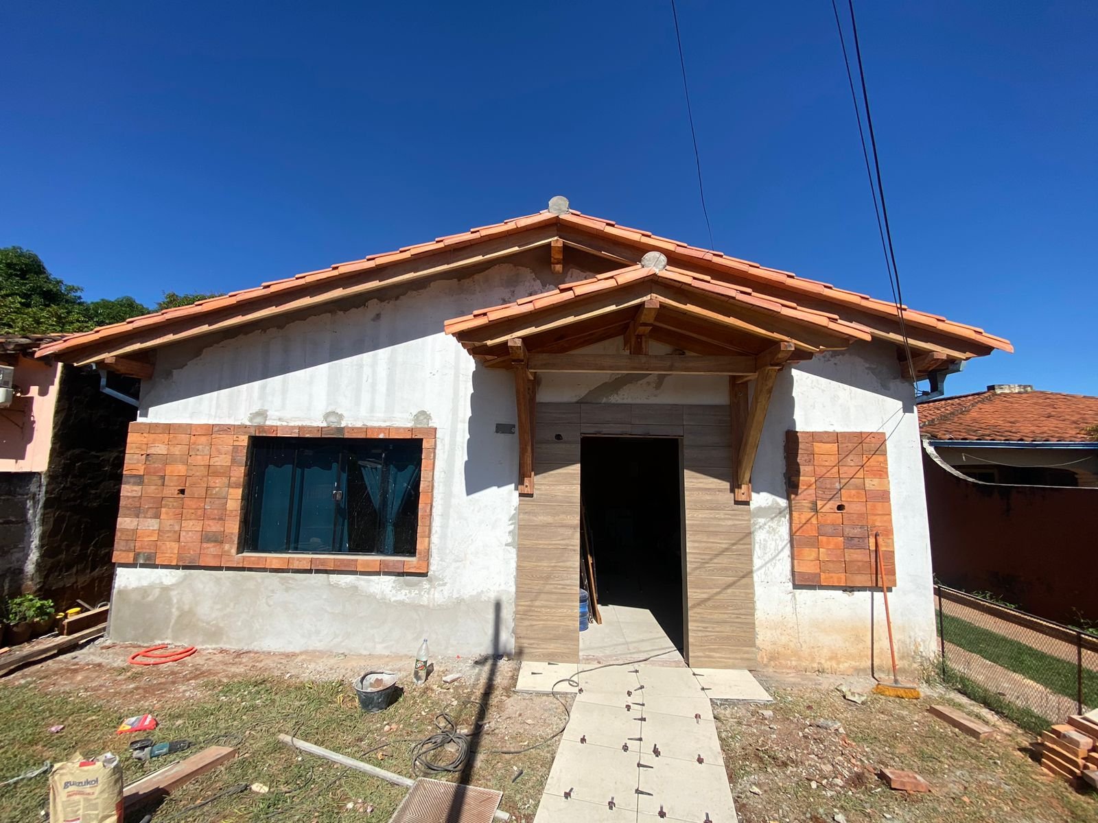 Fachada renovada en revestimiento simil piedra con cielo despejado, San Lorenzo - OGA Constructora