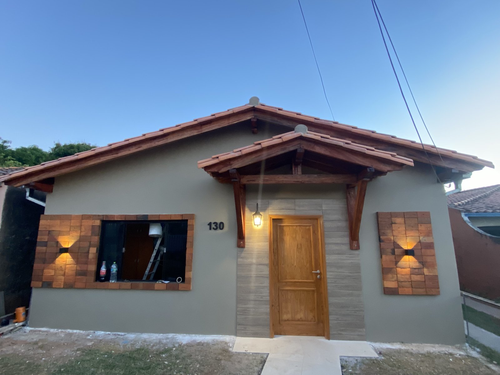 Frente renovado de vivienda con revestimiento simil piedra, San Lorenzo - OGA Constructora