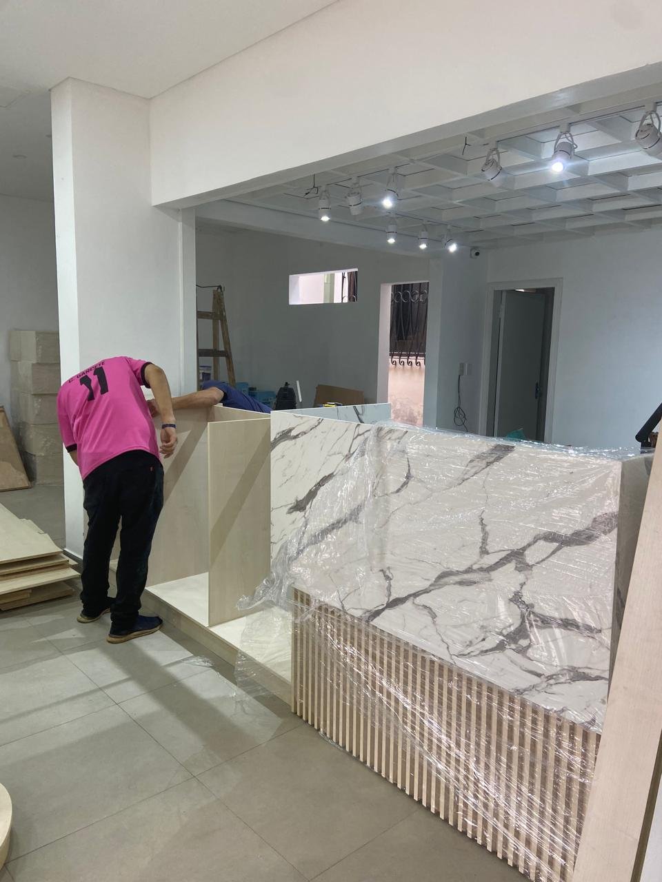 Sector de recepcion con mostrador de marmol, libreria San Buenaventura Yaguaron - OGA Constructora