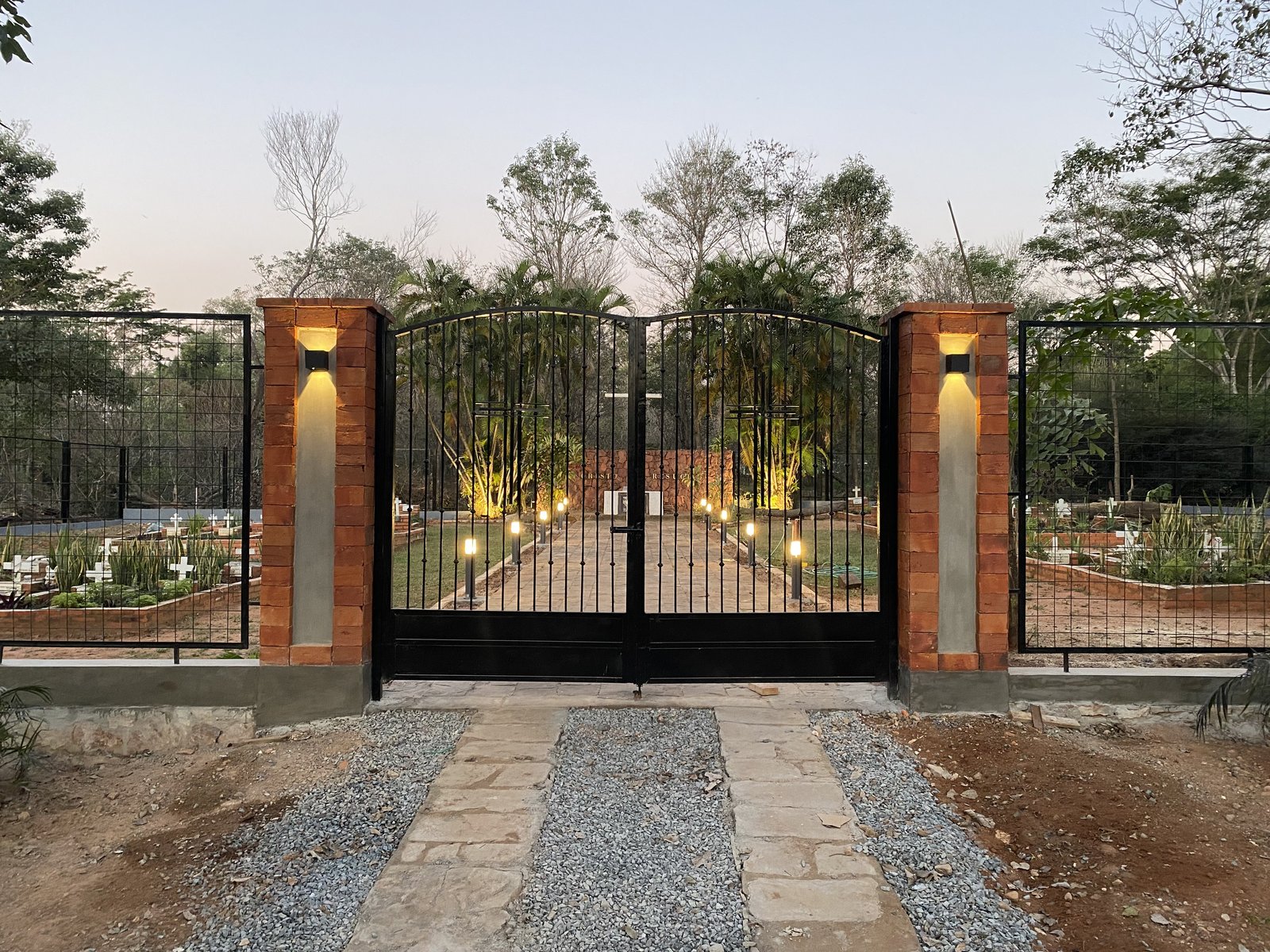 Porton de acceso con columnas iluminado al atardecer, memorial Hermanas Dominicas - OGA Constructora