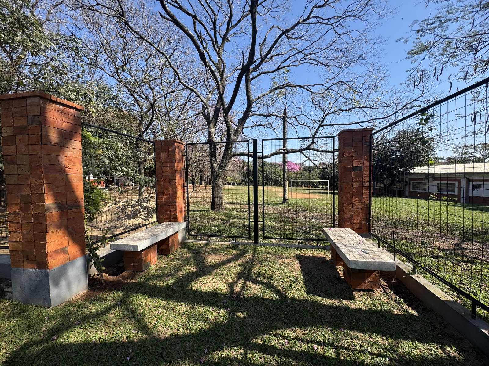 Columna con banco entre la vegetacion, memorial Hermanas Dominicas - OGA Constructora
