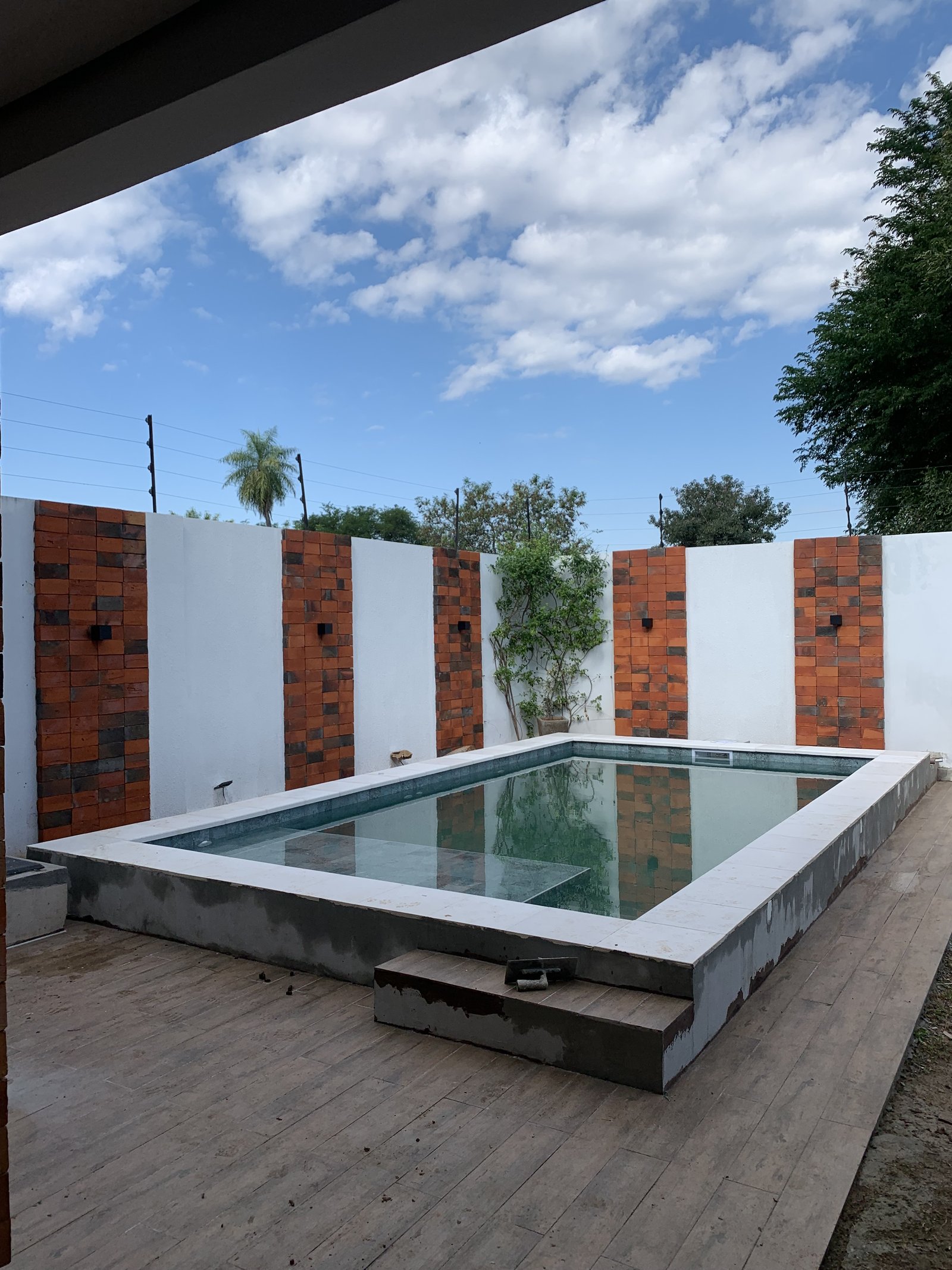 Piscina terminada con cielo despejado, remodelacion en Loma Pyta - OGA Constructora