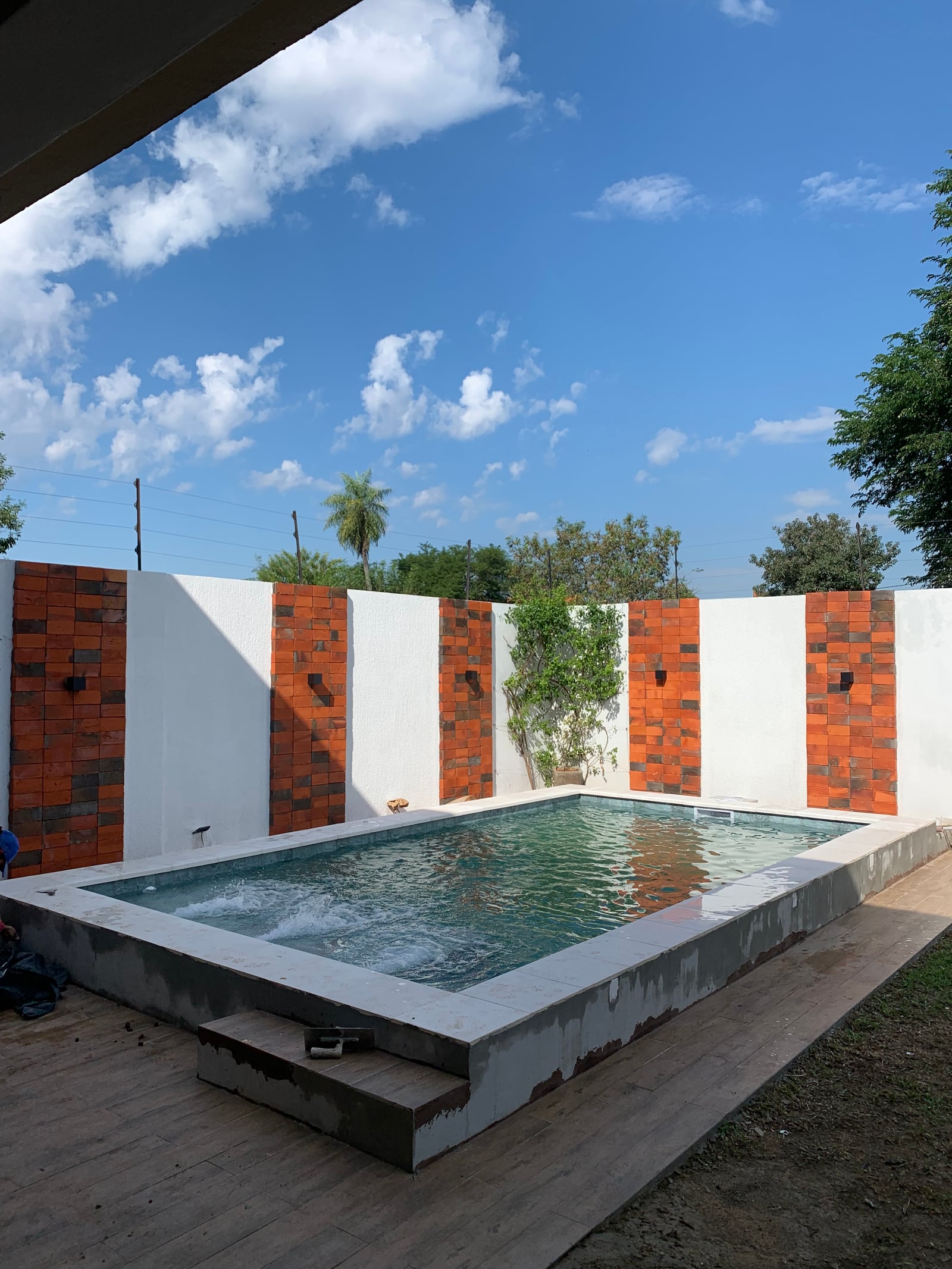 Vista en angulo de la piscina y el muro decorativo, Loma Pyta - OGA Constructora