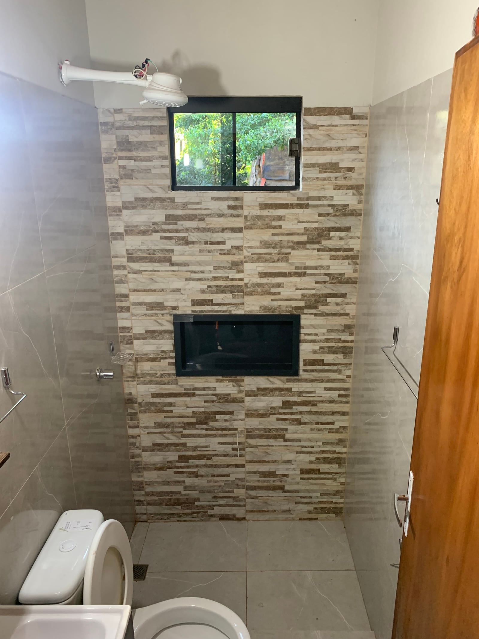 Baño con muro de piedra y espejo, vivienda Lucas San Lorenzo - OGA Constructora