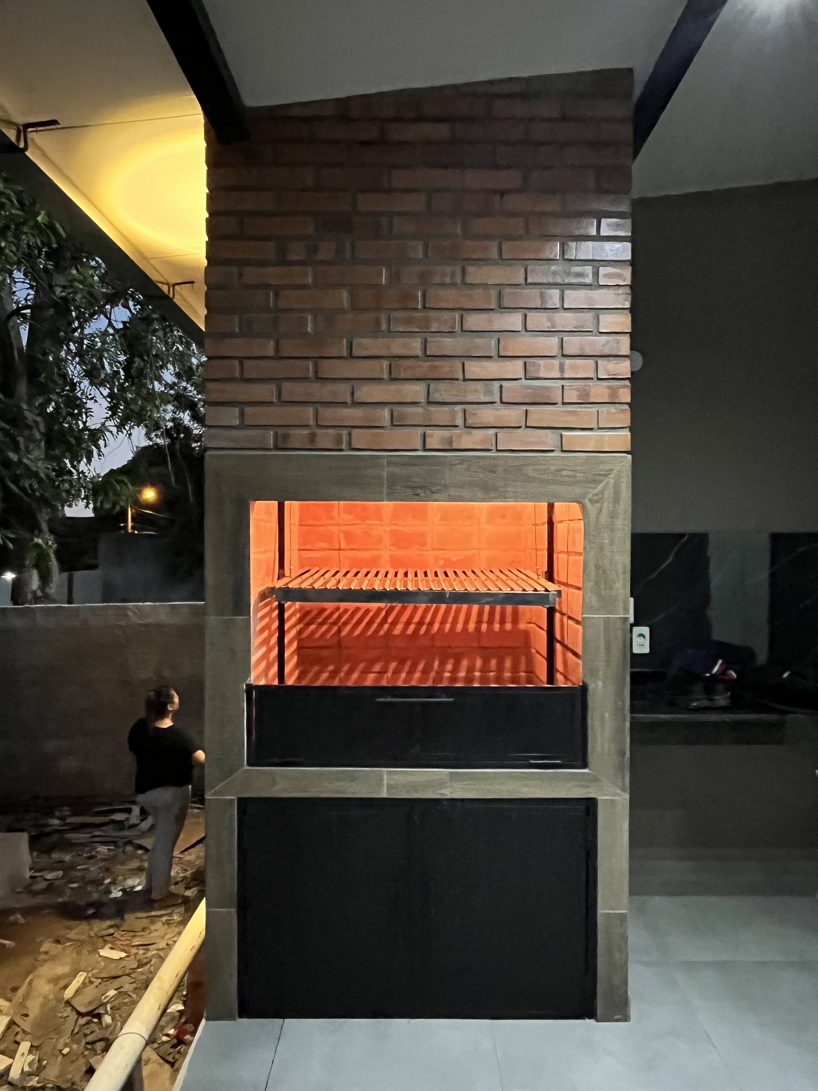 Quincho con parrilla encendida y vista al patio, vivienda Mile San Lorenzo - OGA Constructora