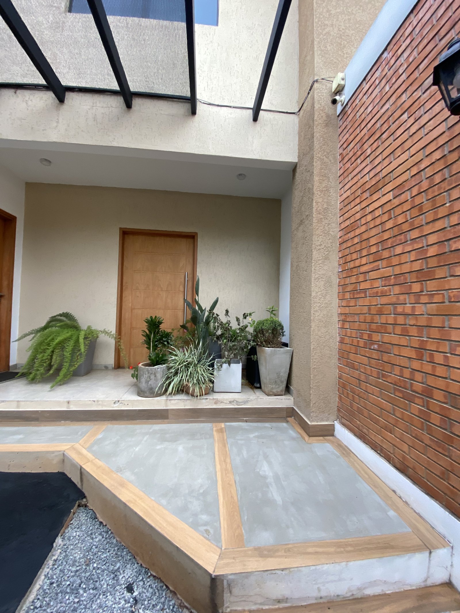 Acceso peatonal con jardinera de la vivienda - OGA Constructora