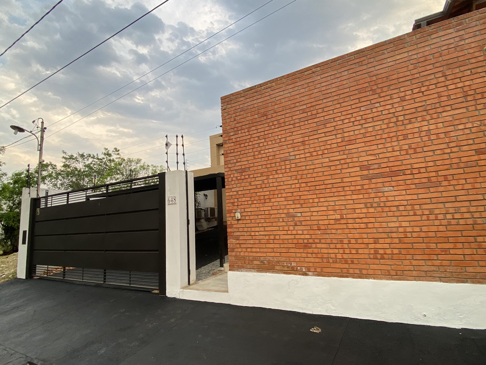 Muro perimetral en ladrillo visto de la vivienda - OGA Constructora