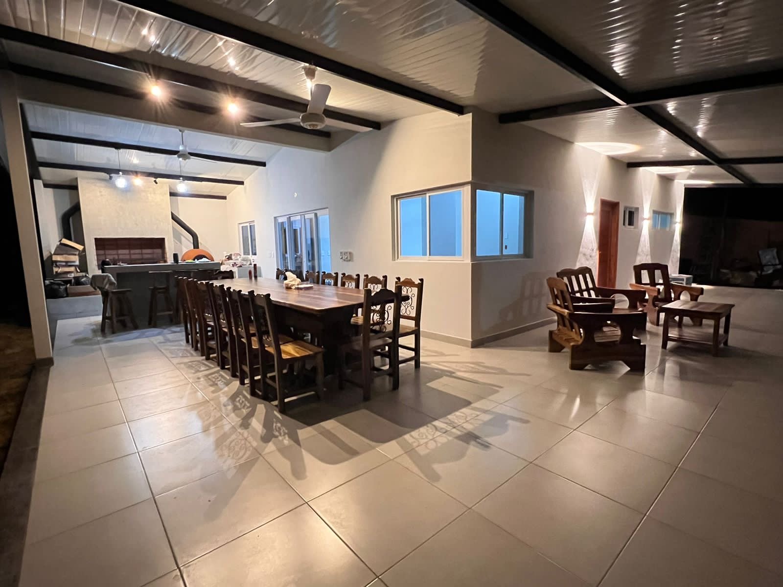 Comedor con cocina abierta bajo techo de estructura metalica y madera, Yaguaron - OGA Constructora