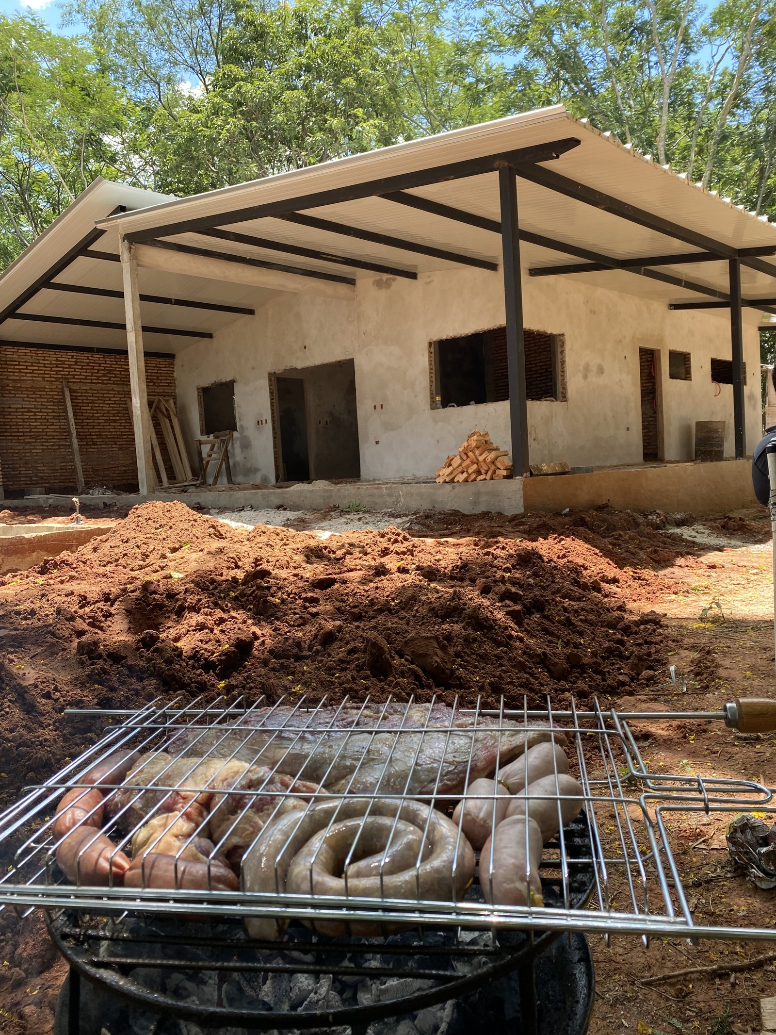 Asador con carne a la parrilla en quincho de vivienda, Yaguaron - OGA Constructora