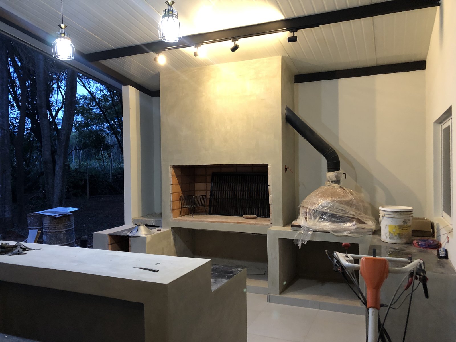 Quincho interior con hogar a lena y parrilla en terminacion, Yaguaron - OGA Constructora