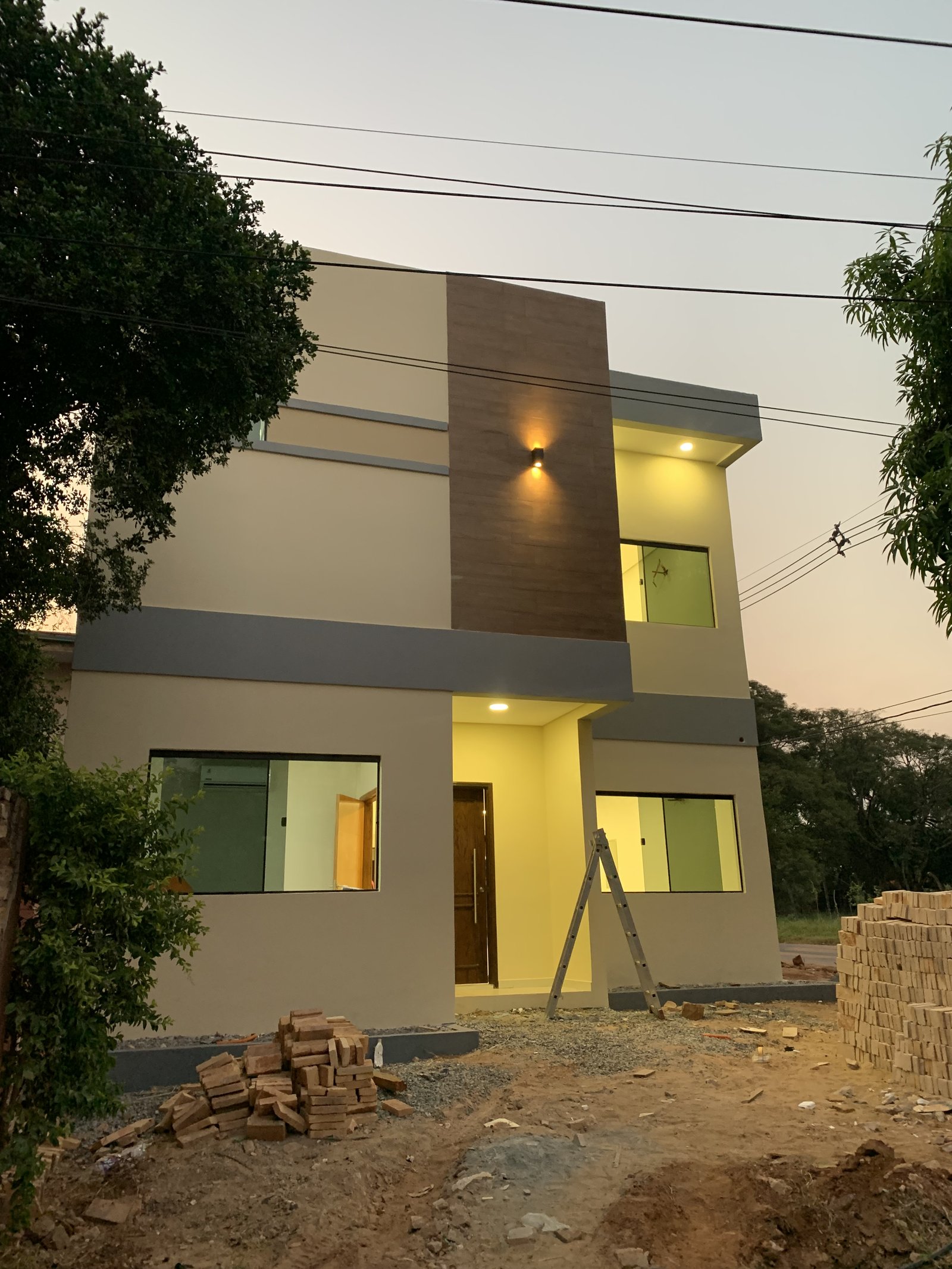 Fachada de la vivienda Ruben Aranda en etapa de terminacion al atardecer, Luque - OGA Constructora