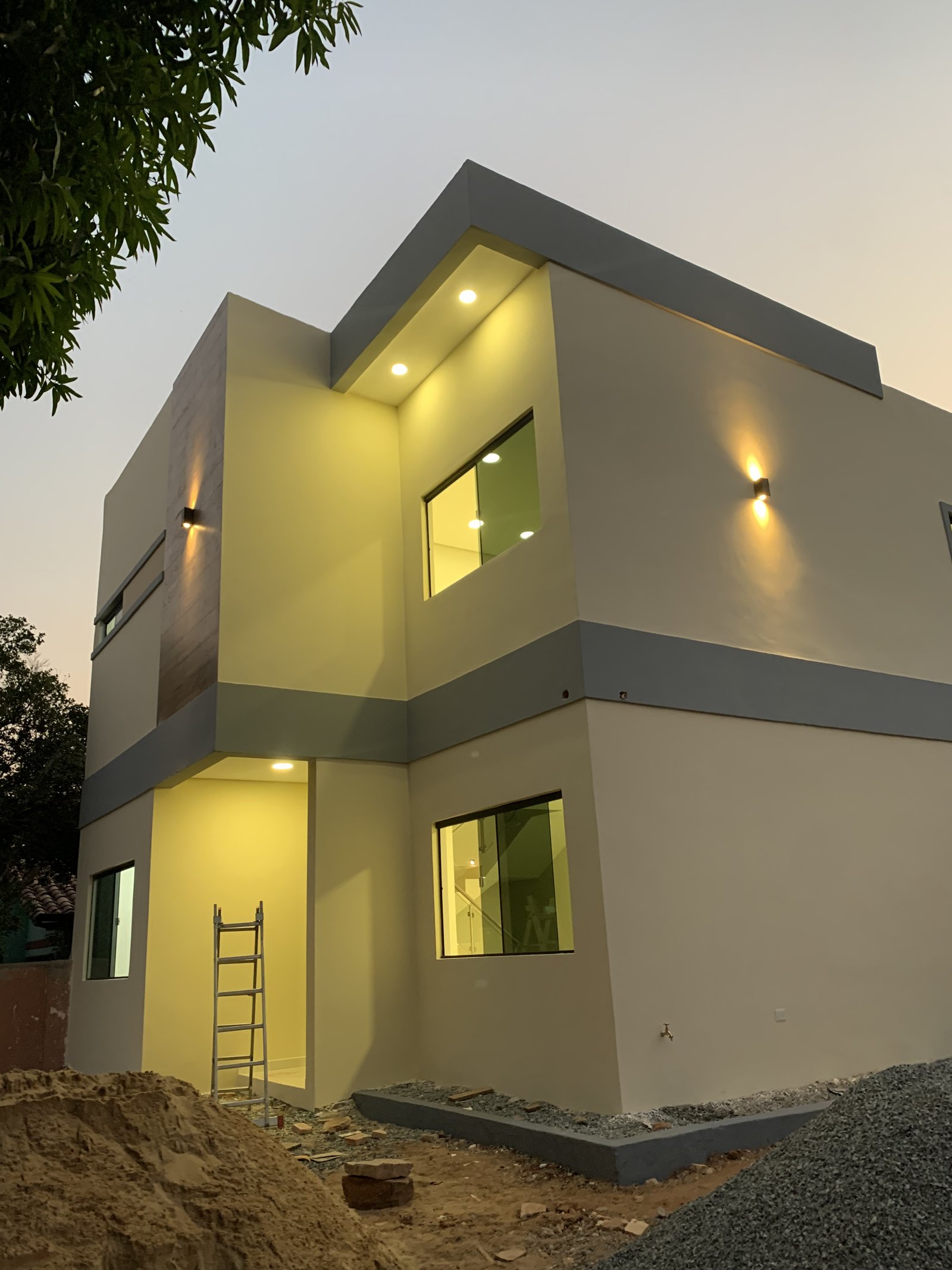 Fachada de la vivienda Ruben Aranda al atardecer, Luque - OGA Constructora