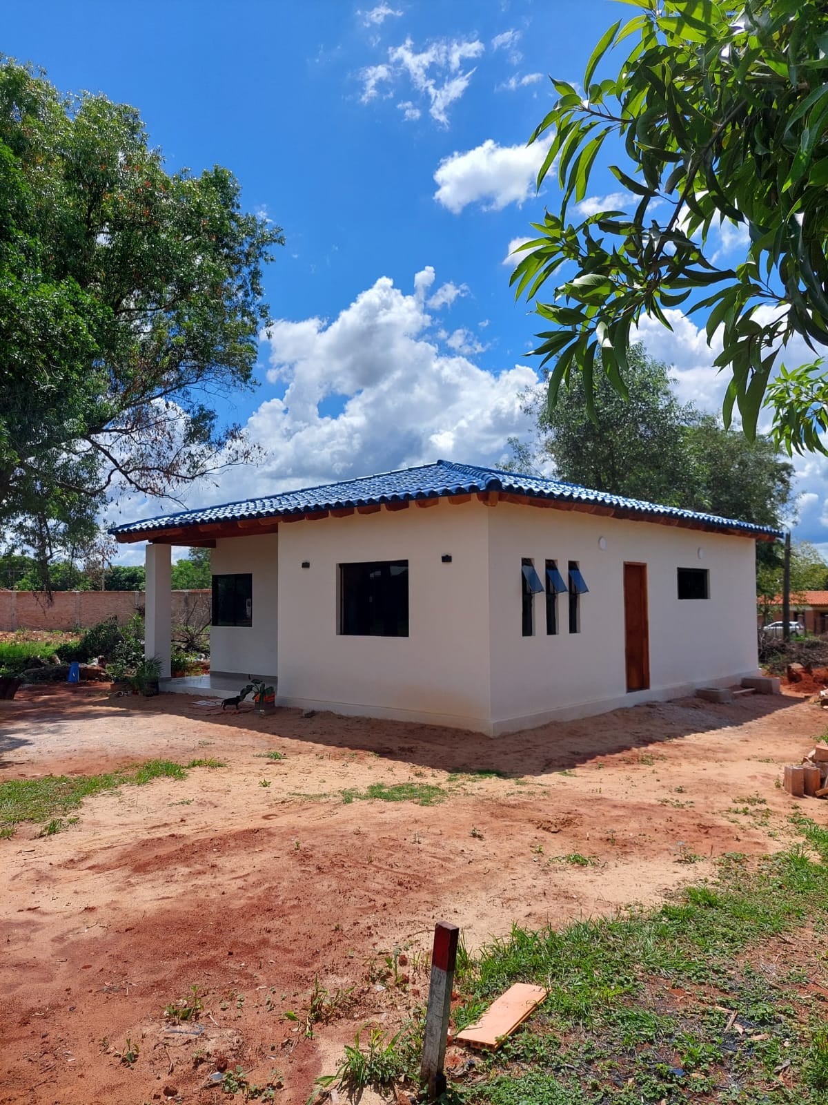Fachada de vivienda de una planta en ladrillo visto con techo de madera, Luque - OGA Constructora