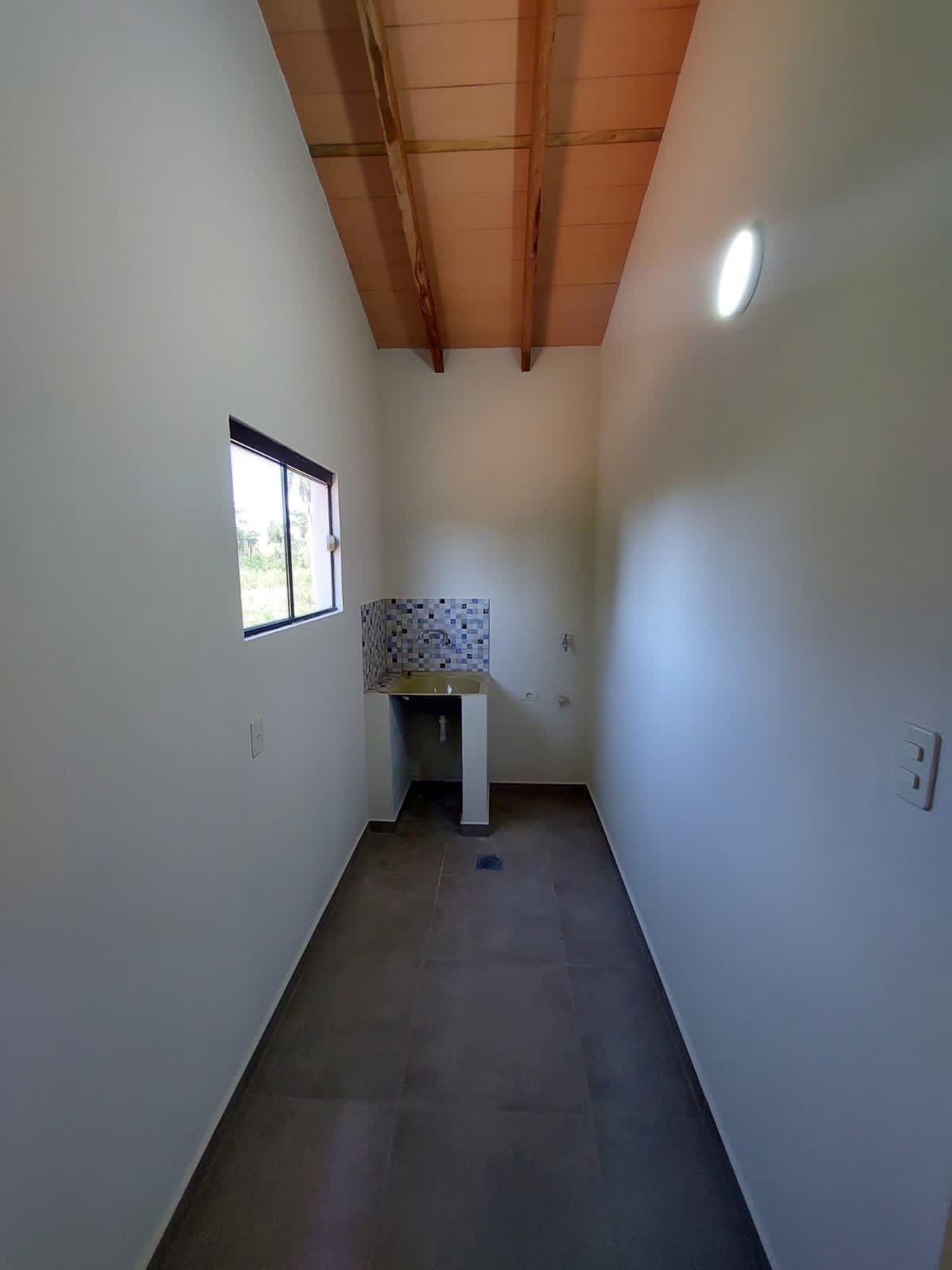 Ambiente interior con cielorraso de tablas de madera, vivienda Luque - OGA Constructora